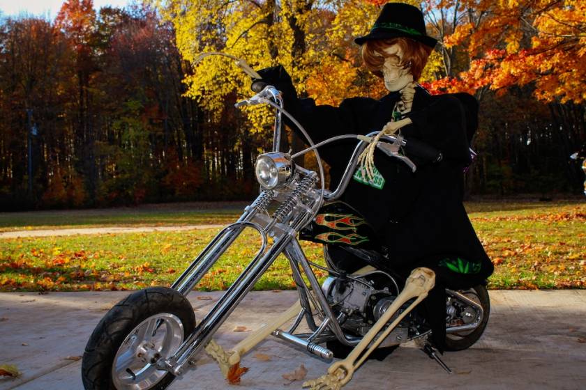 Skeleton biker sitting on a motorcycle during autumn color tours