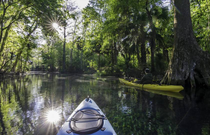 two people kayaking through calm water in florida 